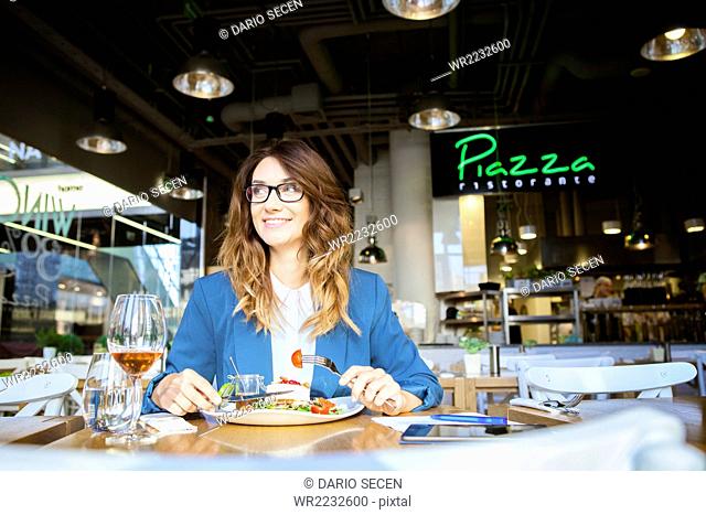 Mid adult woman lunching in restaurant