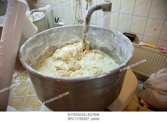 A machine kneading bread dough at a bakery