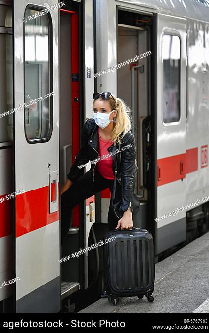 Woman with face mask, entering train, corona crisis, main station, Stuttgart, Baden-Württemberg, Germany, Europe