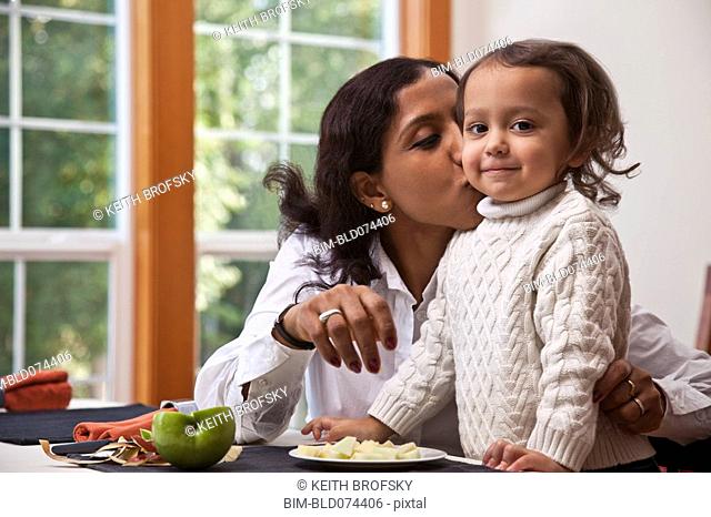 Indian mother kissing daughter