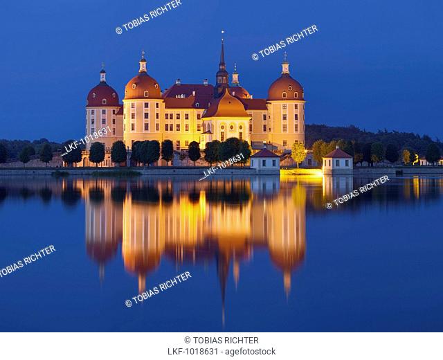 Baroque Moritzburg castle at dusk with its reflection in the castle pond, near Dresden, Saxony, Germany
