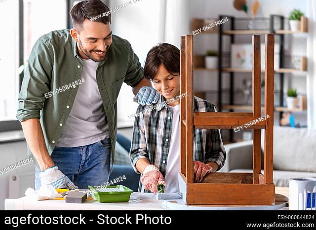 father and son painting old table in grey color