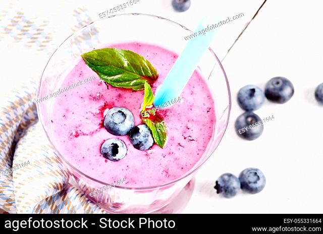 Mason jar with Blueberry shake on white table. Smoothie concept