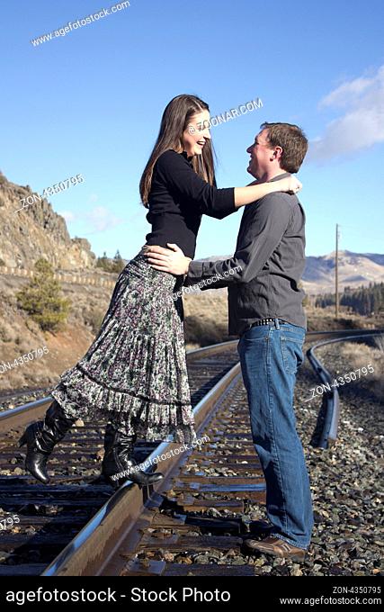 a young couple on the train tracks