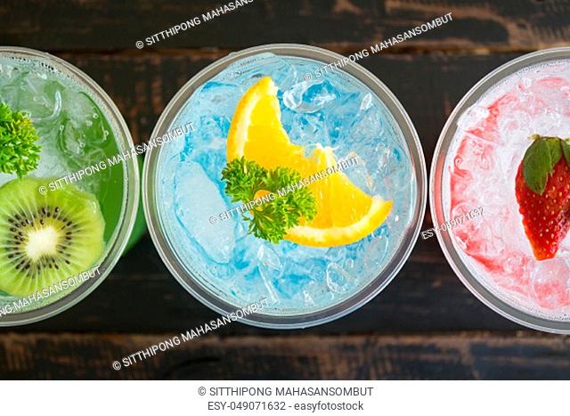 Green Blue Red Italian Soda Cold Beverage and Kiwi Lemon Strawberry Fruit and Parsley. Green Blue Red Italian Soda Cold Beverage on wood table for food and...