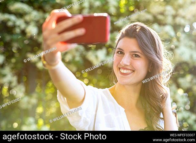 Smiling woman taking a selfie outdoors