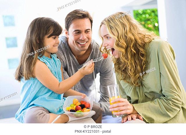Girl feeding fruit salad to her mother
