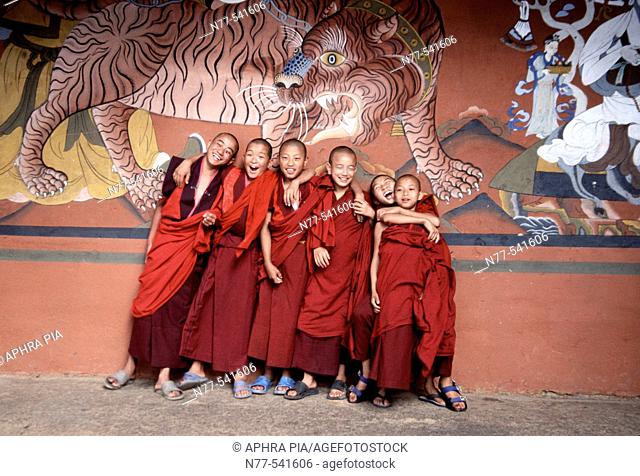Young buddist monks under a tiger mural. Paro Dzong, Bhutan