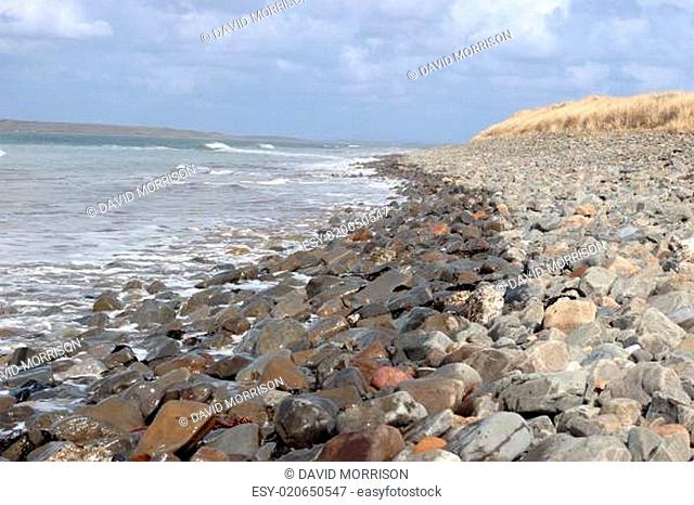 rolling waves on pebbled dune coastline