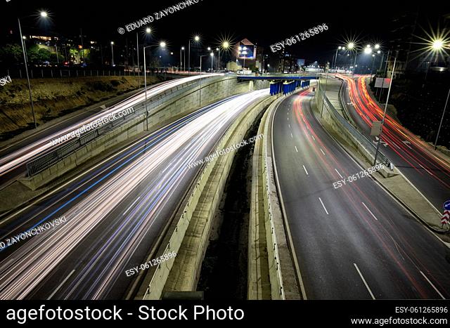 Night traffic junction road with lights of vehicle movement. Horizontal view
