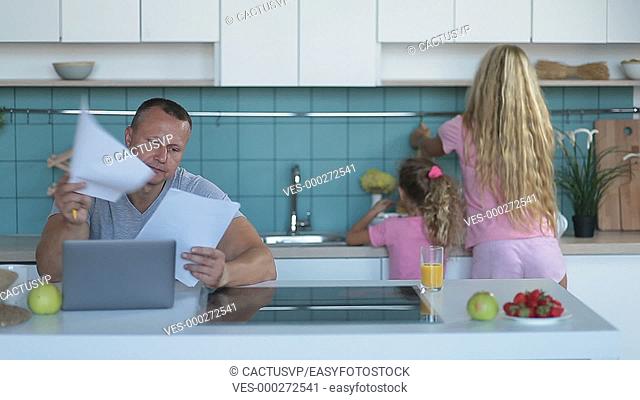 Stressed man browsing bills and documents at home