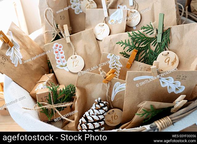 Decorated brown bags with gift boxes and pine cones kept in basket