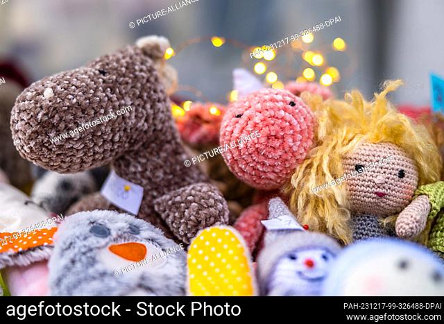 16 December 2023, Brandenburg, Leuthen: Handmade knitted dolls lie on a stall at a small Advent market. Advent and Christmas markets are also held in many...