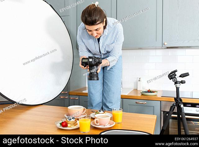food photographer with camera working in kitchen