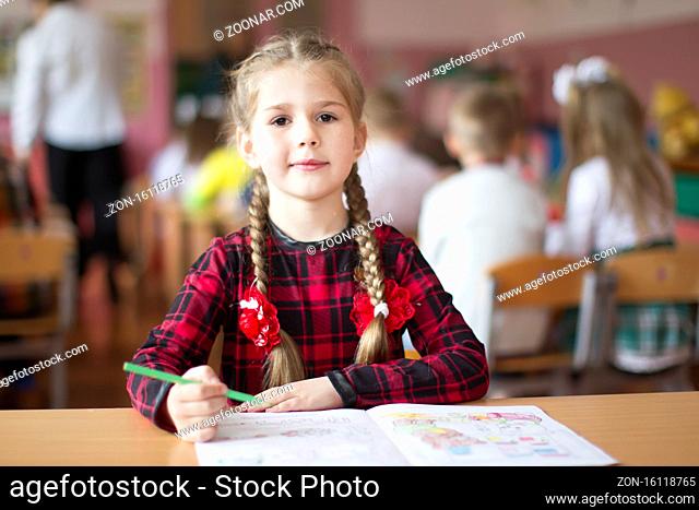 Belarus, the city of Gomil, May 10, 2019. Open day in kindergarten. Preschooler girl with a book. First-grader. Portrait of a kindergarten graduate