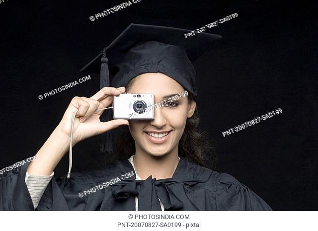 Portrait of a young female graduate taking a picture