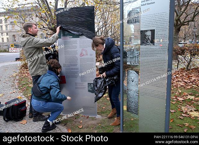 16 November 2022, Berlin: People remove a protective film before the start of the dedication of the memorial stele ""Colonial Involvements of the Museum of...