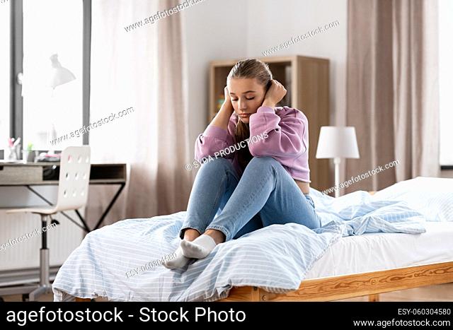 sad girl sitting on bed at home