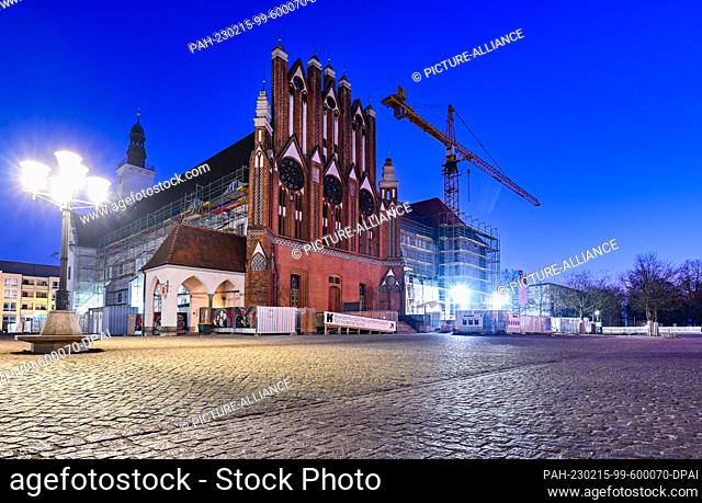 15 February 2023, Brandenburg, Frankfurt (Oder): A construction crane stands next to scaffolding on the southern façade of the Oder city hall early this morning