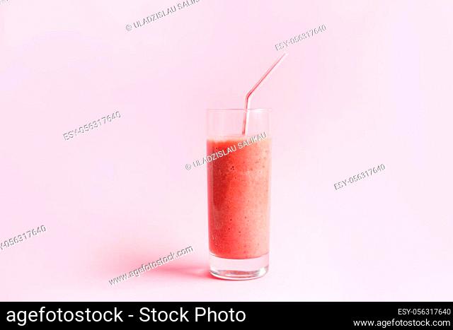 Strawberry smoothie or milkshake in mason jar on pink pastel background. Healthy food for breakfast and snack