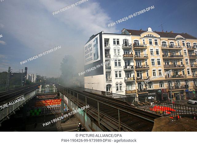 26 April 2019, Hamburg: In the event of a fire in an apartment building, smoke crosses the tracks at Sternschanze S-Bahn station