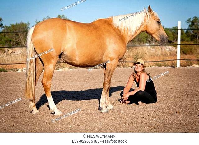 junge weibliche reiterin trainiert ihr pferd im freien im sommer