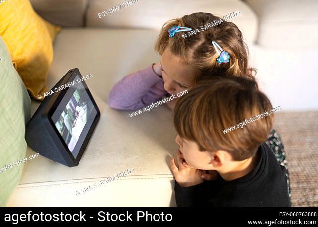 Couple of children watching attentively video screen