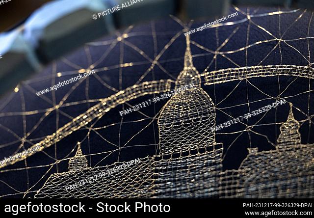 PRODUCTION - 21 November 2023, Saxony, Annaberg-Buchholz: A lace motif of St. Anne's Church in Annaberg adorns a candle arch in the lace-making school in...