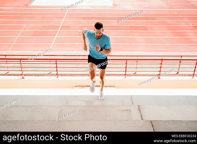 Male athlete running up steps in stadium