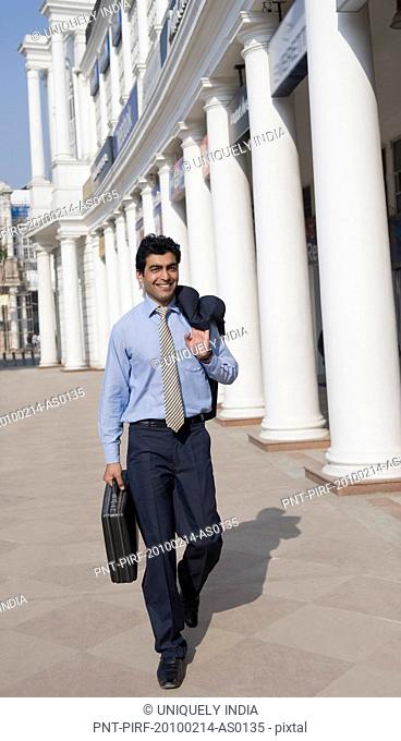 Businessman walking with a briefcase, Gurgaon, Haryana, India