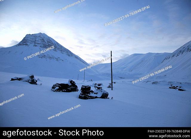 FILED - 25 February 2023, Norway, Longyearbyen: Snowed-in snowmobiles standing in front of a valley on Spitsbergen. Photo: Steffen Trumpf/dpa