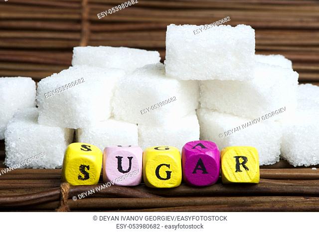 Sugar lumps and word sugar. Multicolored cubes