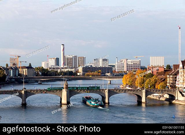 Basel, Switzerland - October 24, 2016: Container ship on the Rhine river passing under Middle Bridge in the city center