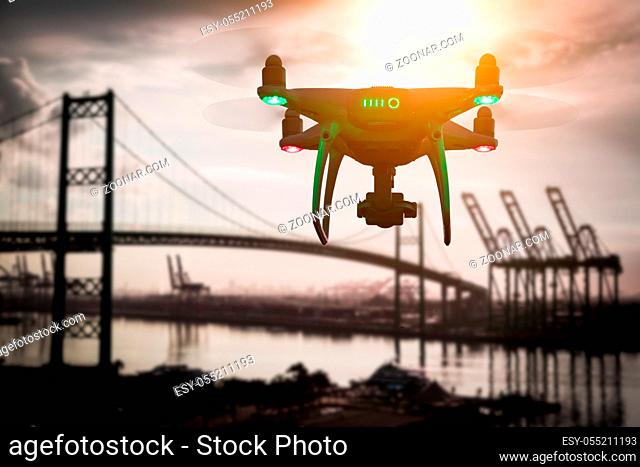 Silhouette of Unmanned Aircraft System (UAV) Quadcopter Drone In The Air Over Shipping Port