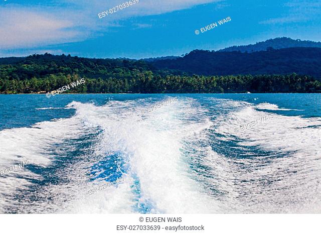 Water stream after speed boat. Trail on water surface behind of fast moving motor boat. Waves on blue sea