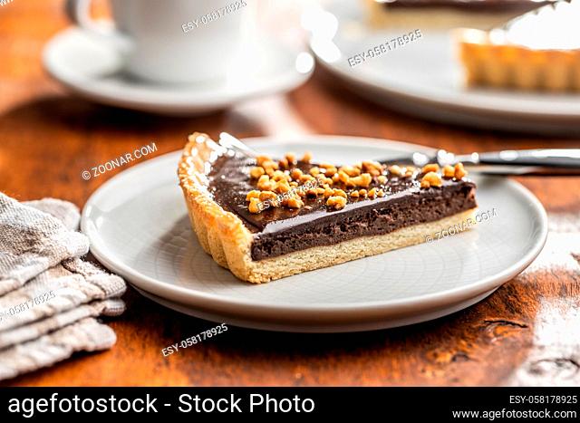 Sweet chocolate pie with crushed nuts on plate
