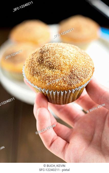 A hand holding a Nutella doughnut muffin