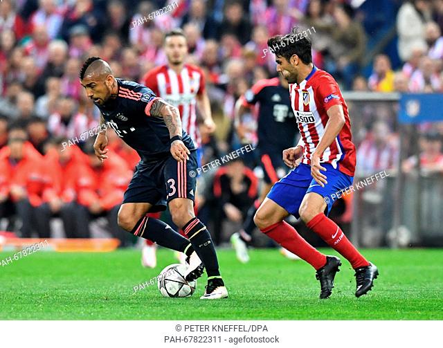 Munich's Arturo Vidal (L) and Madrid'sAugusto Fernandez vie for the ball during the Champions League semi-final match between Atletico Madrid and Bayern Munich...