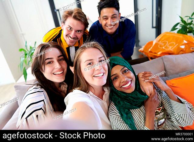 group of casual multiethnic business people during break from the work taking selfie picture while enjoying free time in relaxation area at modern open plan...