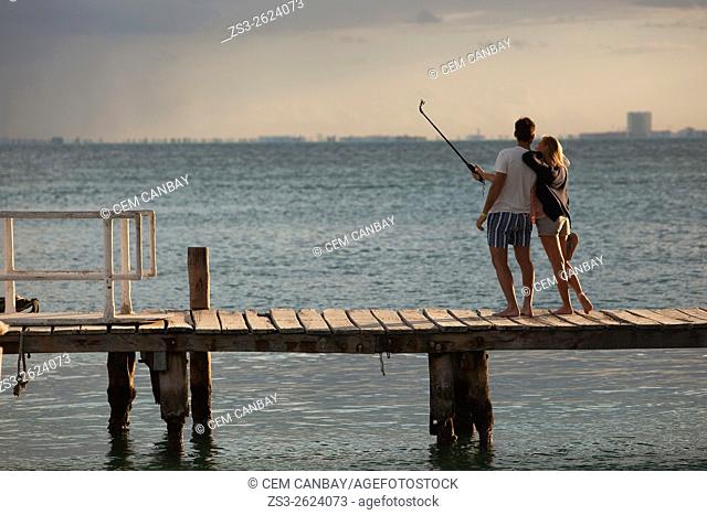 Young couple making a selfie standing and posing on a pier, Isla Mujeres, Cancun, Quintana Roo, Yucatan Province, Mexico, North America