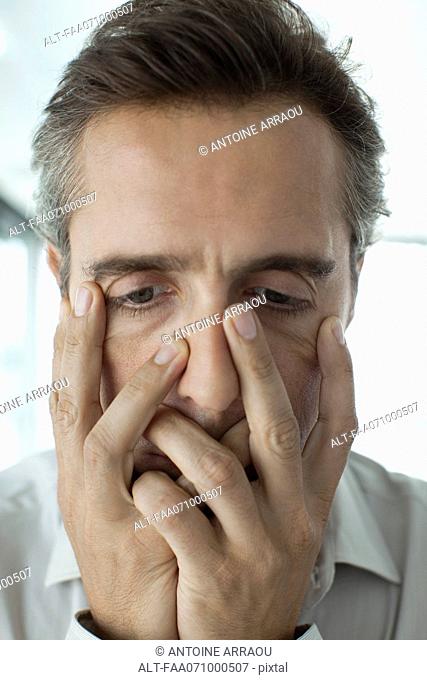 Man with hands covering face