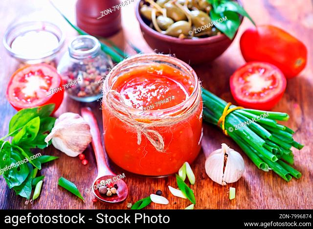 salsa in glass bank and on a table