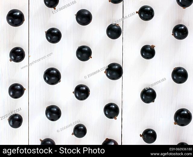 Fresh black currants on white wooden background. blackcurrants pattern for wallpaper. Flay lay or top view