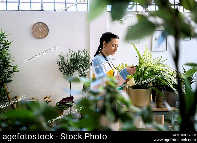 Smiling female gardener working in workshop