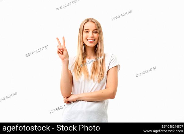 Closeup portrait young happy confident woman giving peace victory, two sign gesture, isolated white studio background. Positive emotion facial expression...