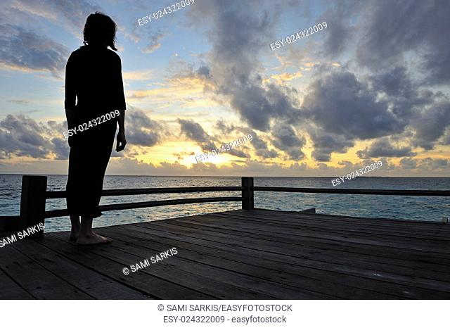 Silhouette of a woman contemplating the sunrise, Island of Borneo, Sabah State, Malaysia