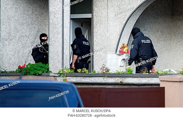 Masked police officers enter a house in Essen,  Germany, 04 November 2015. The Federal Police is proceeding against international organized crime in a...