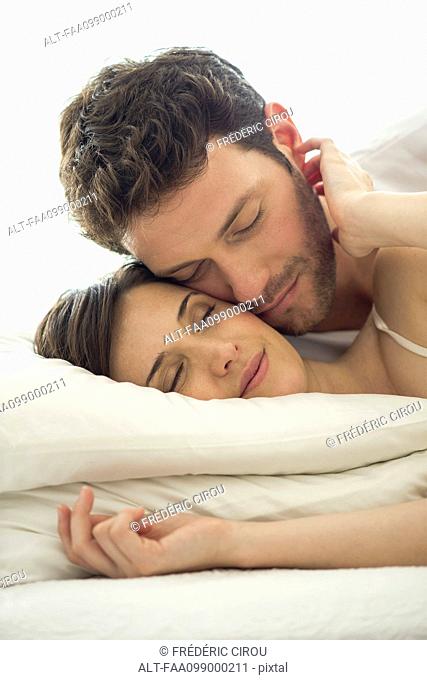 Couple cuddling together in bed