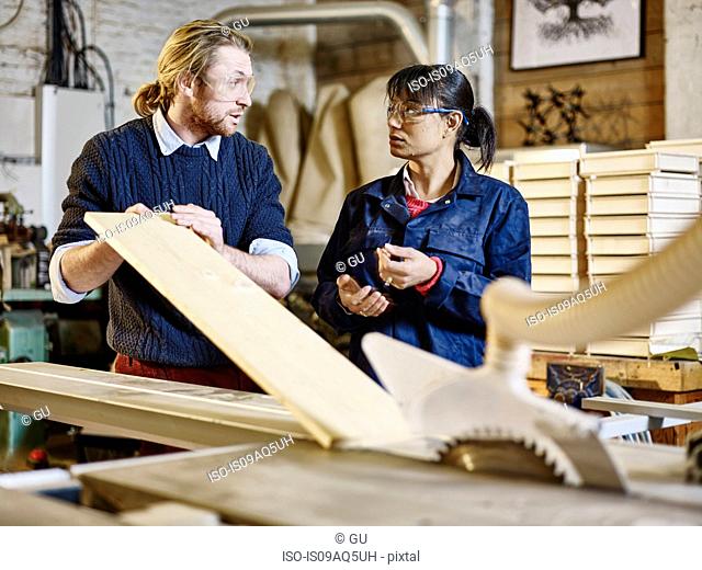 Man explaining to female trainee in printing workshop