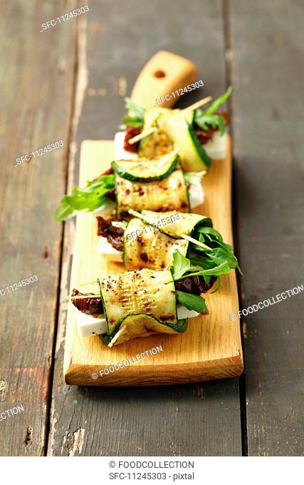Grilled rolled slices of courgette filled with rocket, feta and sundried tomatoes